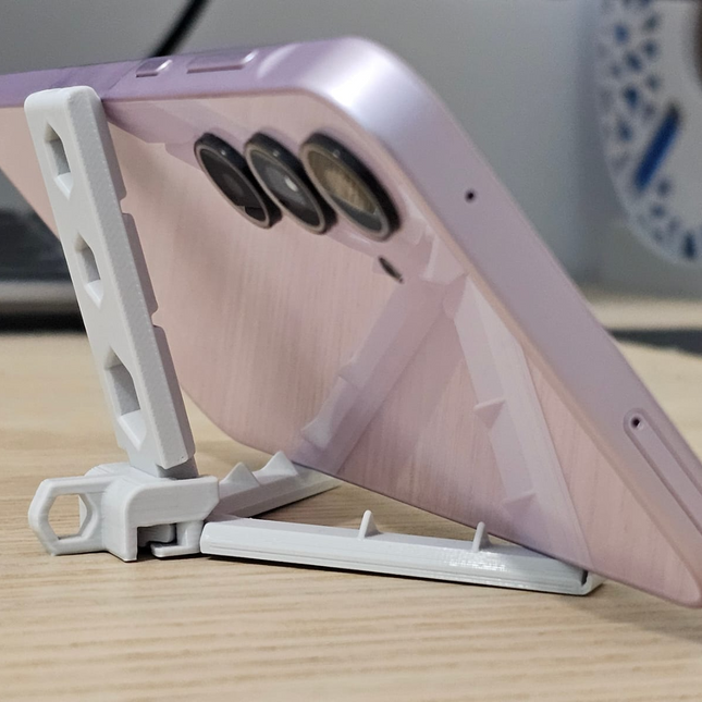 Sulankstomas telefonų stovas su automatiniais laikikliais