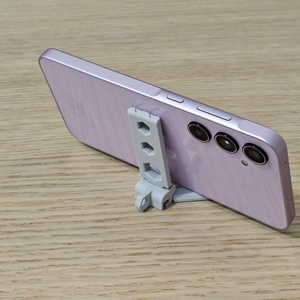 Sulankstomas telefonų stovas su automatiniais laikikliais